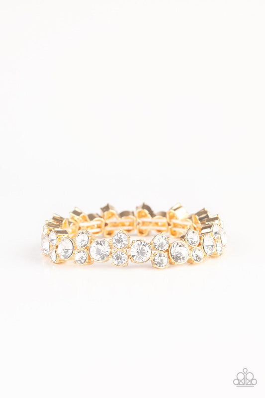 Paparazzi Accessories Here Comes the BRIBE - Gold Featuring sleek gold frames, trios of glittery white rhinestones are threaded along stretchy bands around the wrist for a timeless shimmer. Sold as one individual bracelet. Jewelry