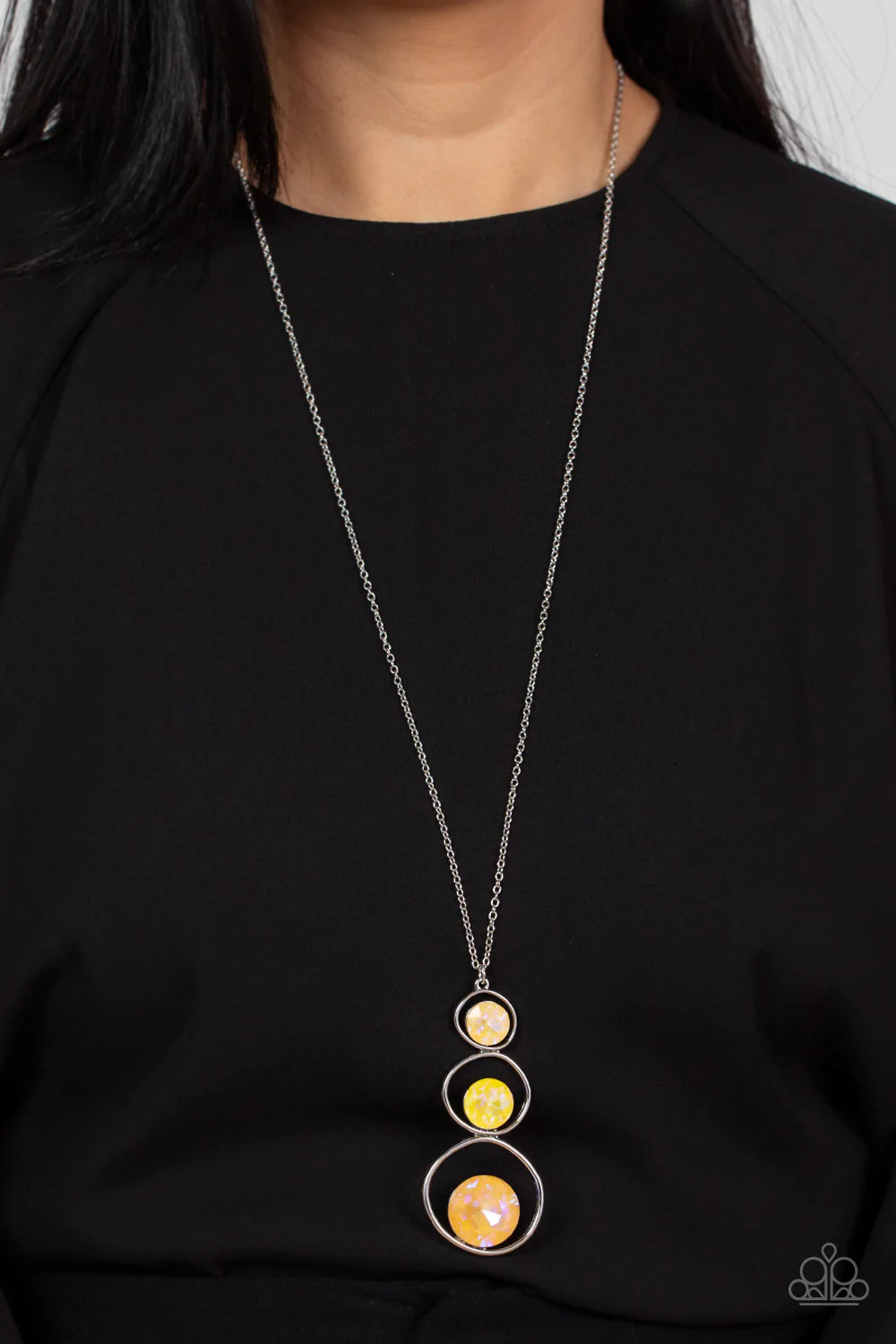 Paparazzi Accessories Celestial Courtier - Yellow A sparkly ombré of iridescent yellow gems adorn the bottoms of three silver hoops that gradually increase in size as they stack into an asymmetrical pendant. The glowing pendant swings from the bottom of a