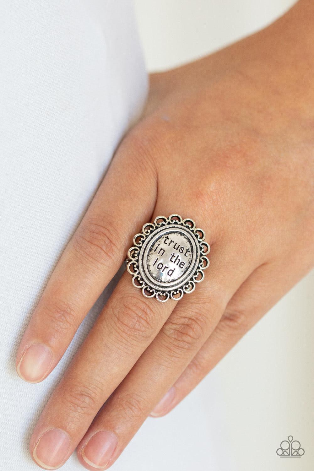Paparazzi Accessories Trust ~Silver The enlightening phrase, "trust in the lord", is stamped in the center of a frilly silver frame for an inspiring look. Features a stretchy band for a flexible fit.