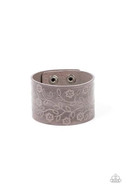 Paparazzi Accessories Rosy Wrap Up - Silver A flowery and leafy motif blooms across the front of a distressed gray leather band, resulting in a rustic floral centerpiece around the wrist. Features an adjustable snap closure. Sold as one individual bracele