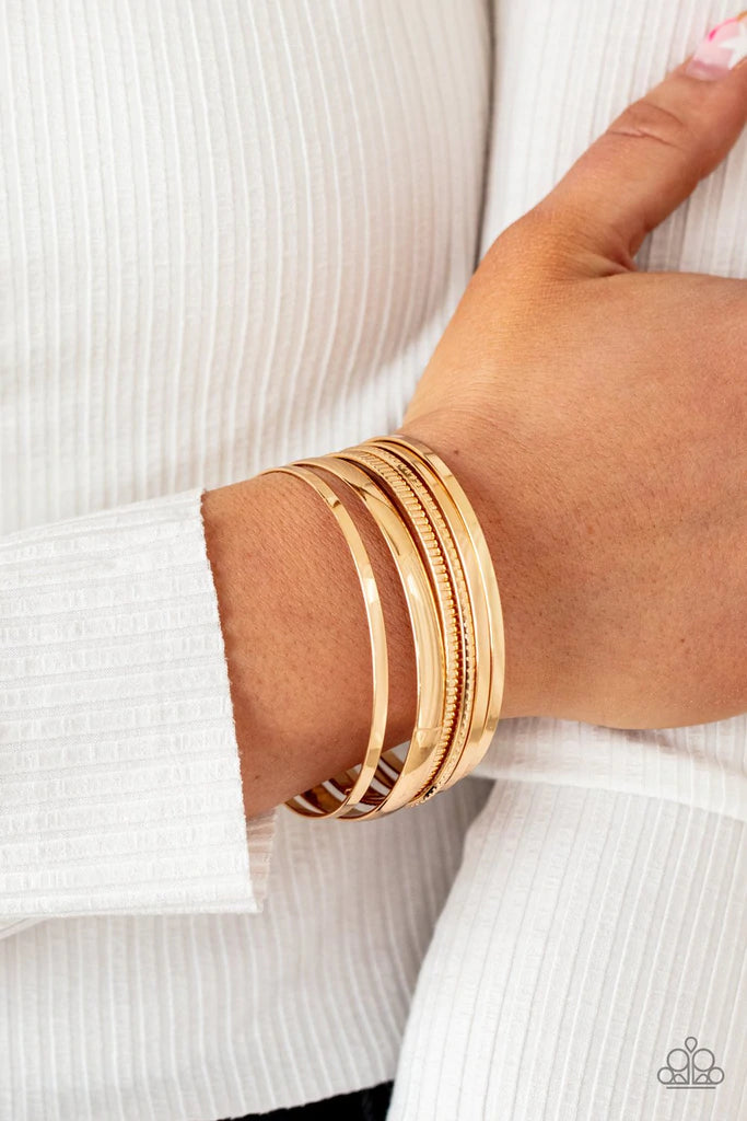 Paparazzi Accessories Gliding Gleam - Gold A set of gleaming gold smooth and textured bangles twinkle and chime as they stack up the wrist for a striking finish. Jewelry