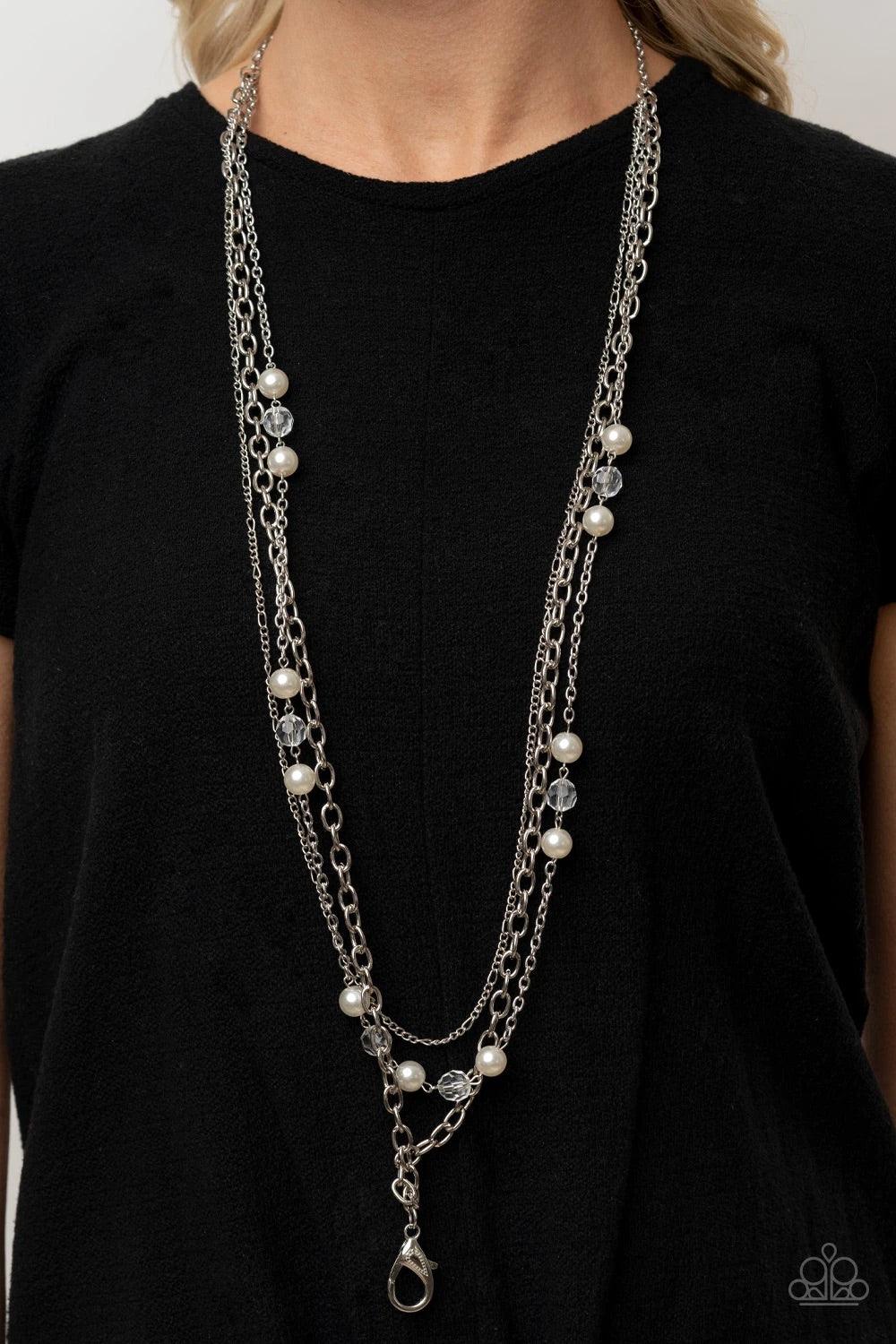 Paparazzi Accessories GLEAM Work - White *Lanyard Dotted with sections of white pearls and glassy crystal-like accents, mismatched layers of shimmery silver chain layer across the chest for a refined flair. A lobster clasp hangs from the bottom of the des