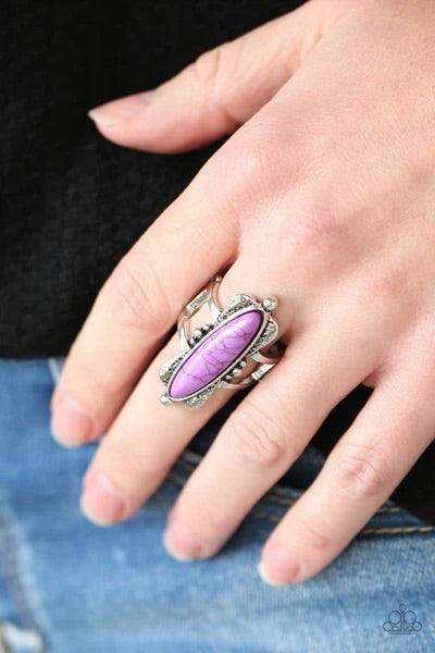 Paparazzi Accessories Cottage Craft - Purple An oblong purple stone is pressed into a flared silver frame featuring studded accents, creating an abstract centerpiece atop the finger. Features a stretchy band for a flexible fit. Sold as one individual ring