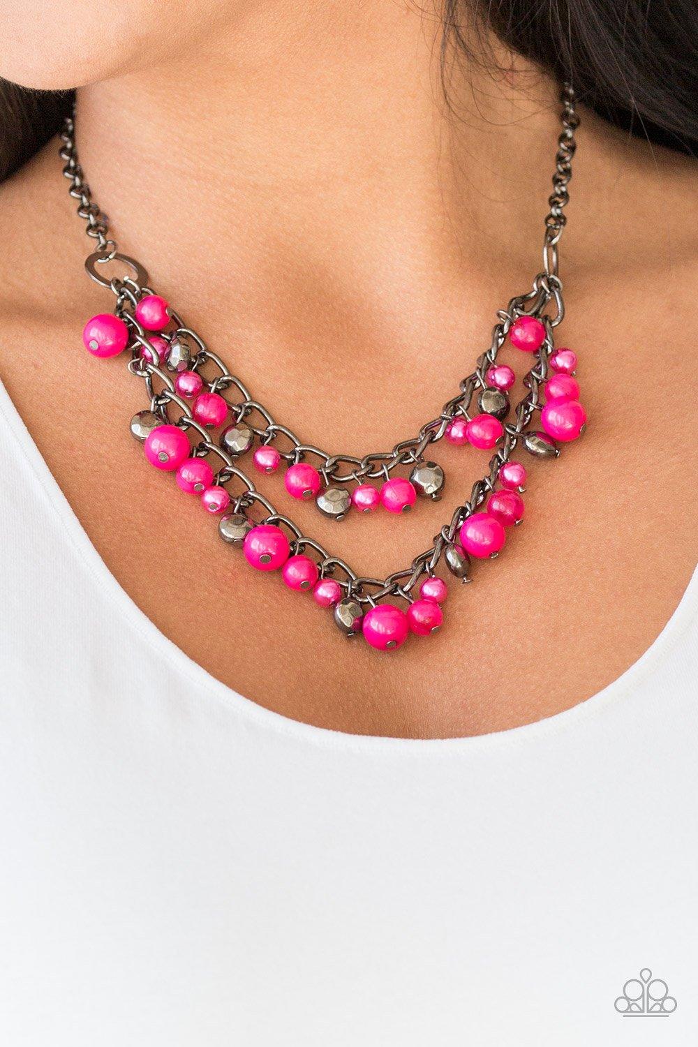 Paparazzi Accessories Watch Me Now - Pink Pearly and polished pink beading joins faceted gunmetal beads along a bold gunmetal chain, creating a sassy fringe below the collar. Features an adjustable clasp closure. Sold as one individual necklace. Includes