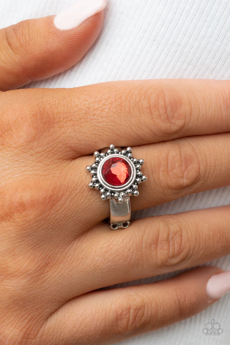 Paparazzi Accessories Expect Sunshine & Reign - Red Dainty silver studs radiate out from an oversized red rhinestone center, resulting into a radiant sunburst frame atop the finger. Features a dainty stretchy band for a flexible fit. Sold as one individua