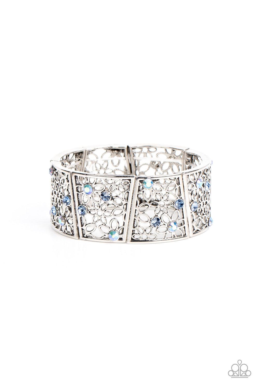 Paparazzi Accessories Spring Greetings - Blue Sporadically dotted with multicolored and iridescent rhinestones, an airy daisy pattern blooms inside trapezoidal silver frames that are threaded along stretchy bands around the wrist for a seasonal statement.