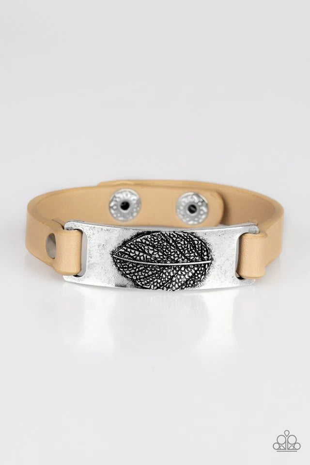 Paparazzi Accessories Take The LEAF - Brown Brushed in an antiqued finish, a life-like leaf is embossed in the center of a silver plate. Soybean leather bands loop through the silver centerpiece and are studded in place across the wrist for a seasonal loo