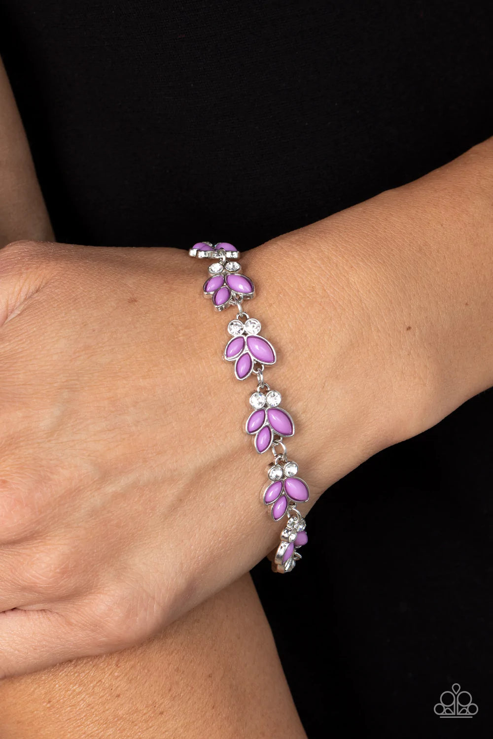 Paparazzi Accessories Vineyard Variety Trios of purple beads fan out from pairs of white rhinestones as they delicately link around the wrist, resulting in colorful leafy accents. Features an adjustable clasp closure. Sold as one individual bracelet.