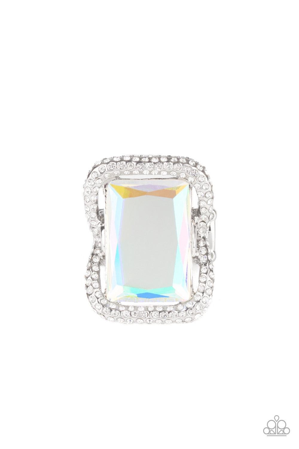 Paparazzi Accessories Deluxe Decadence - Multi Featuring a regal emerald style cut, an oversized iridescent gem nestles inside a rounded square silver frame encrusted in glassy white rhinestones for a dramatically glamorous look. Features a stretchy band