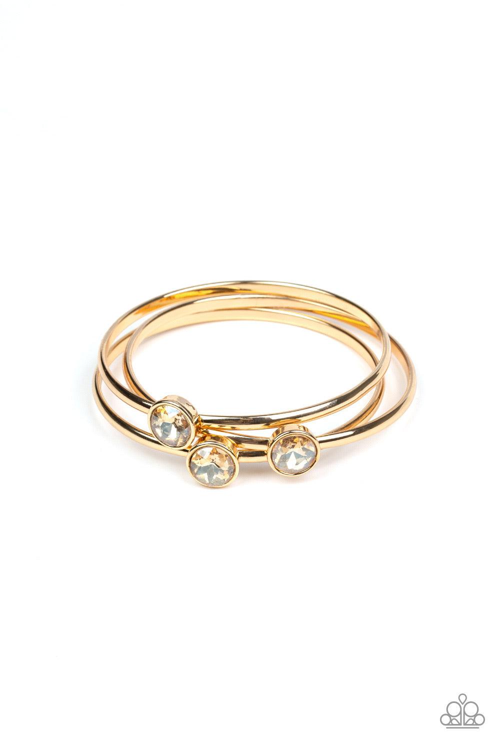 Paparazzi Accessories Be All You Can BEDAZZLE - Gold Encased in sleek gold frames, dazzling golden gems sit atop thick gold bangles for a refined flair. Jewelry