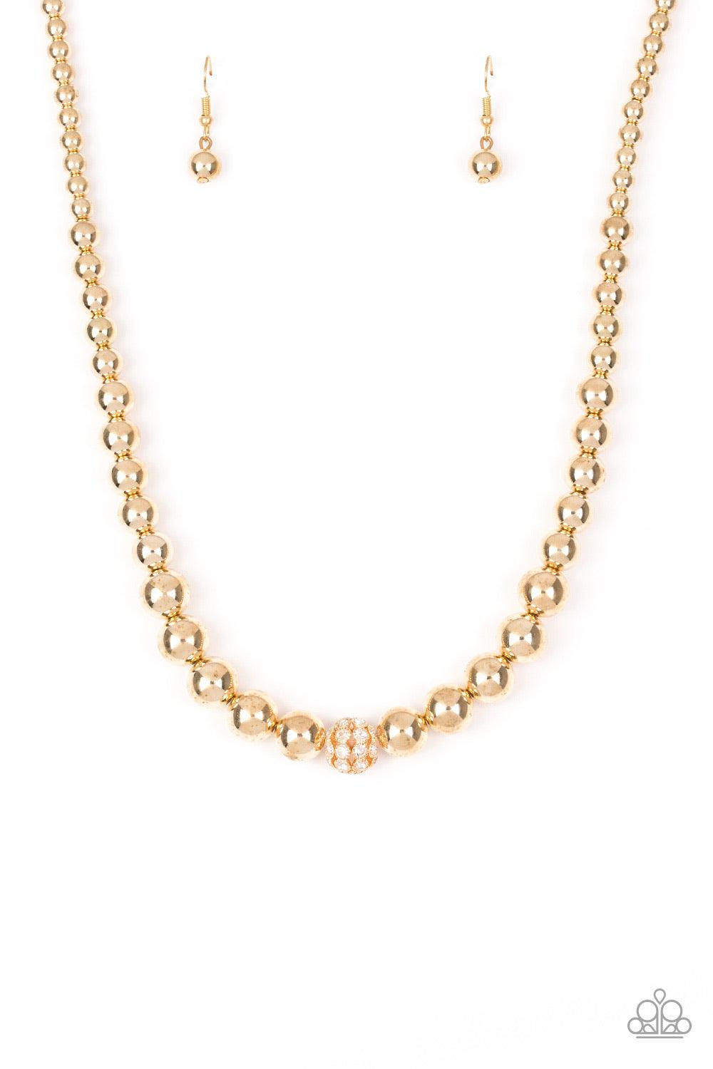 Paparazzi Accessories High-Stakes FAME - Gold Gradually increasing in size near the center, glistening gold beads are threaded along an invisible wire below the collar. Encrusted in glassy white rhinestones, a sparkling gold bead adorns the center for a r