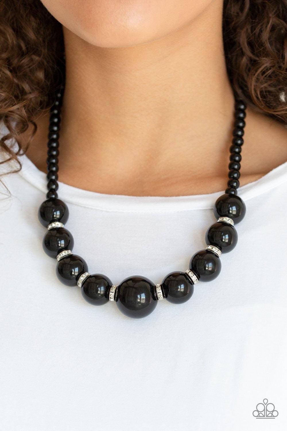Paparazzi Accessories SoHo Socialite - Black Threaded along an invisible wire, classic black beads give way to an alternating collection of over-sized black beads and white rhinestone encrusted rings below the collar for a timeless sparkle. Features an ad