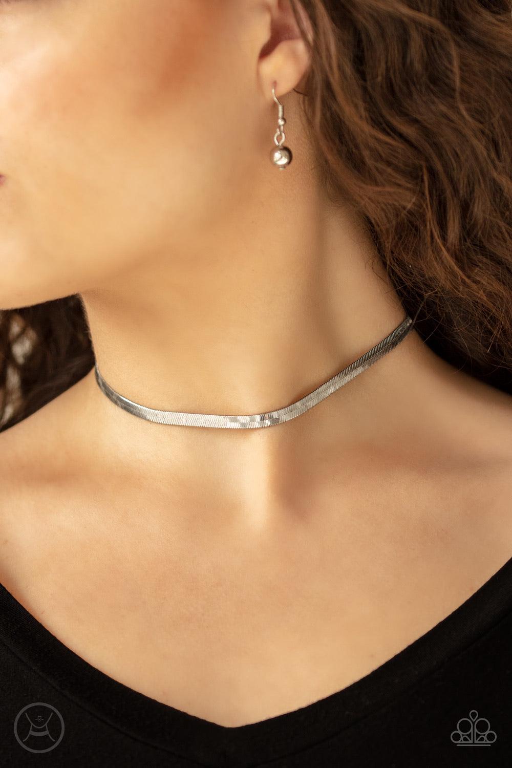 Paparazzi Accessories Serpentine Sheen -Silver A flat row of glistening silver snake chain wraps around the neck for a sleek shimmer. Features an adjustable clasp closure. Jewelry