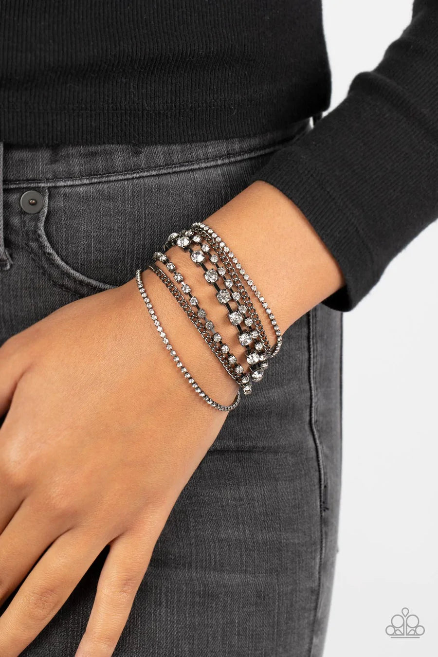 Paparazzi Accessories Interstellar Interlude - Black Set in square gunmetal fittings, strands of sparkly white rhinestones layers around the wrist. Infused with classic gunmetal chains, the sparkly rows stack into an irresistible shimmer. Features an adju