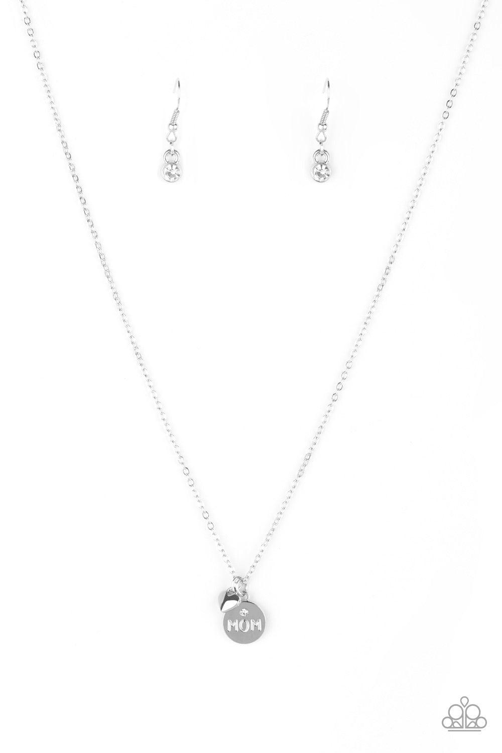 Paparazzi Accessories Worlds Best Mom - White Dotted with a dainty white rhinestone, a shimmery silver disc stamped in the word, "mom", joins a dainty silver heart below the collar for a whimsical look. Features an adjustable clasp closure. Jewelry