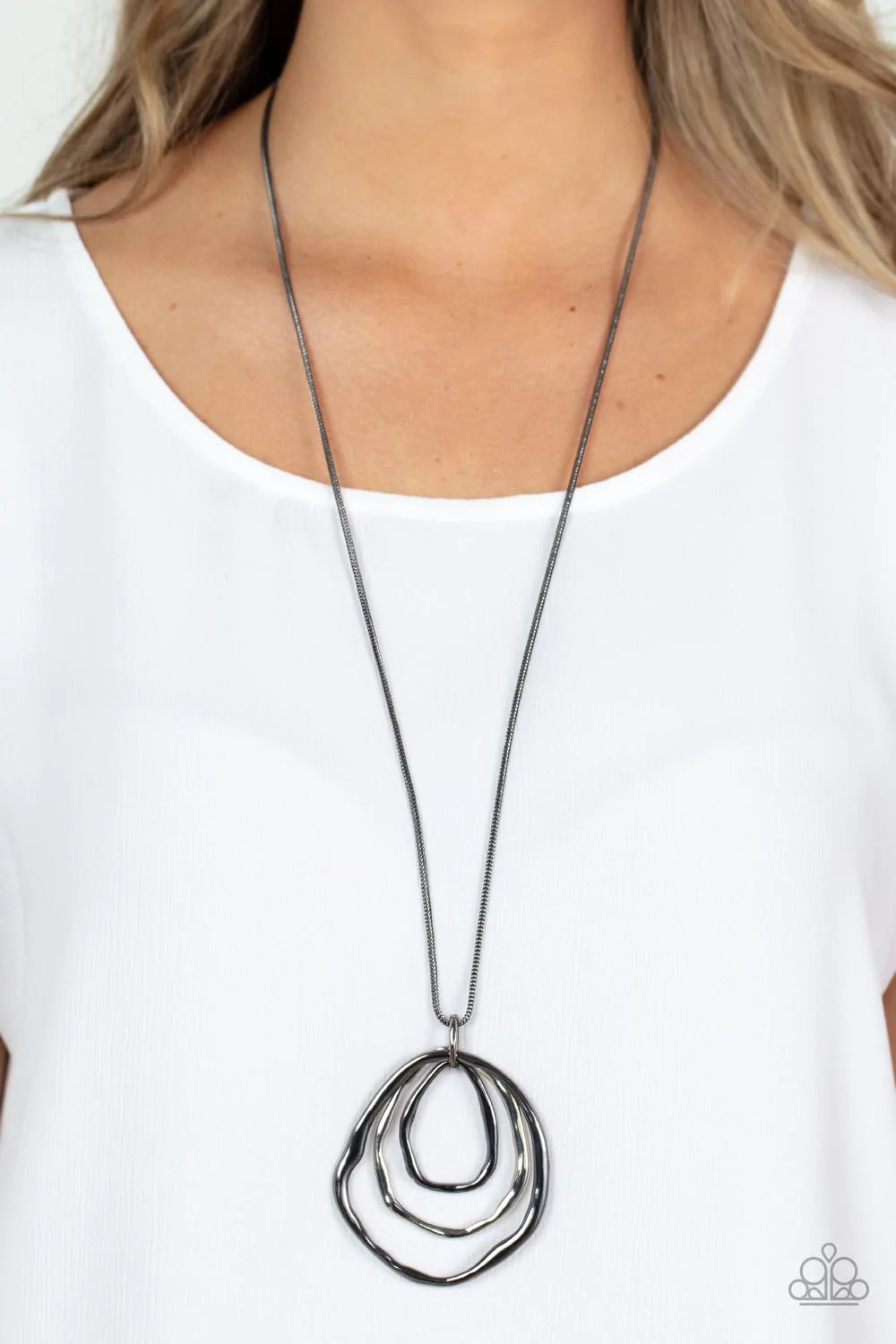 Paparazzi Accessories Revamped Relic - Black A trio of mismatched warped gunmetal and silver rings swing from the bottom of a glistening gunmetal chain, creating an asymmetrically stacked pendant. Features an adjustable clasp closure. Sold as one individu
