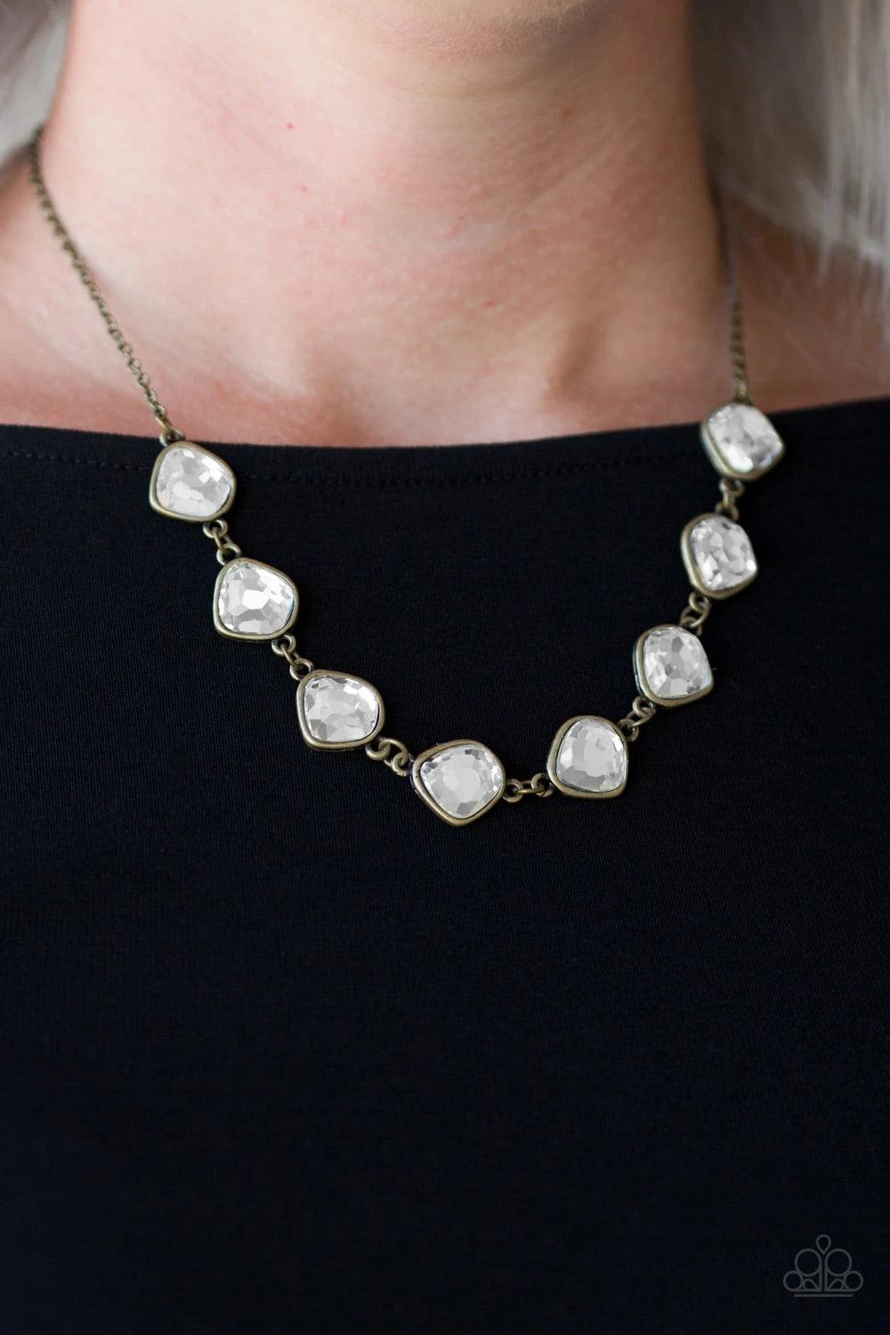 Paparazzi Accessories The Imperfectionist - Brass Featuring antiqued brass frames, imperfect glassy white gems link below the collar for a glamorous vintage inspired look. Features an adjustable clasp closure. Sold as one individual necklace. Includes one