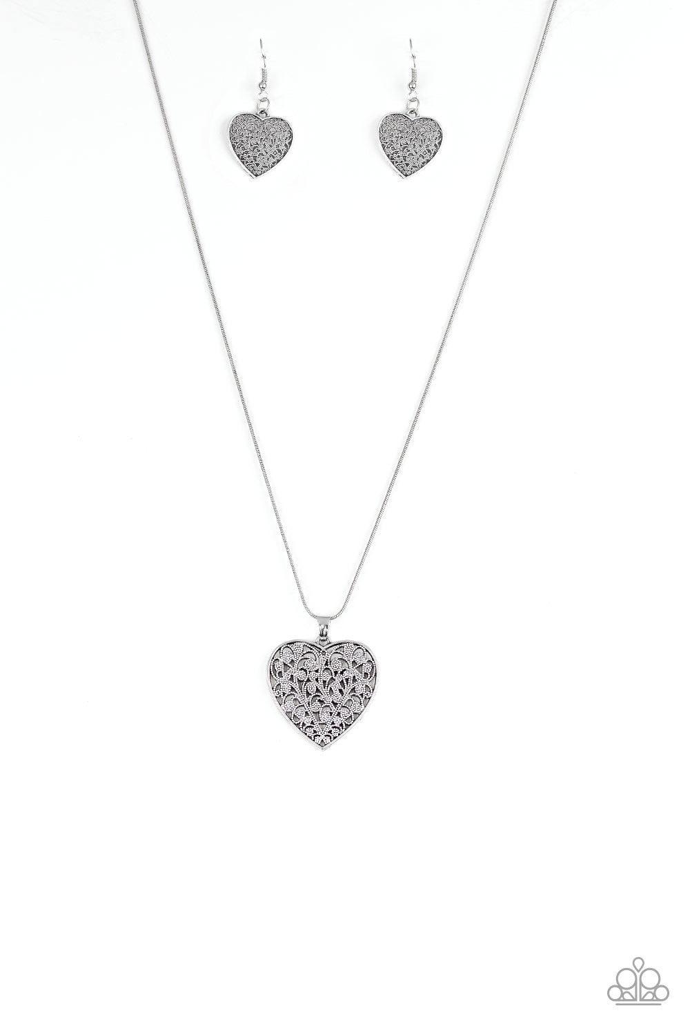 Paparazzi Accessories Look Into Your Heart - Silver Filled with vine-like filigree detail, a silver heart pendant swings below the collar for a vintage inspired look. Features an adjustable clasp closure. Sold as one individual necklace. Includes one pair
