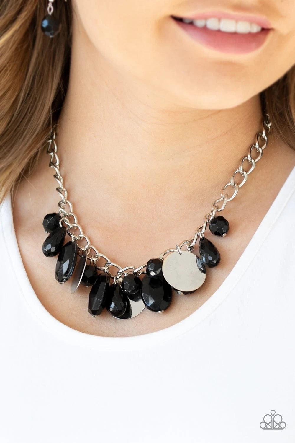 Paparazzi Accessories Treasure Shore - Black A collection of glassy black beads swings playfully from the bottom of a dramatic silver chain. Glistening silver discs trickle between the colorful beads, creating a refreshing fringe below the collar with shi