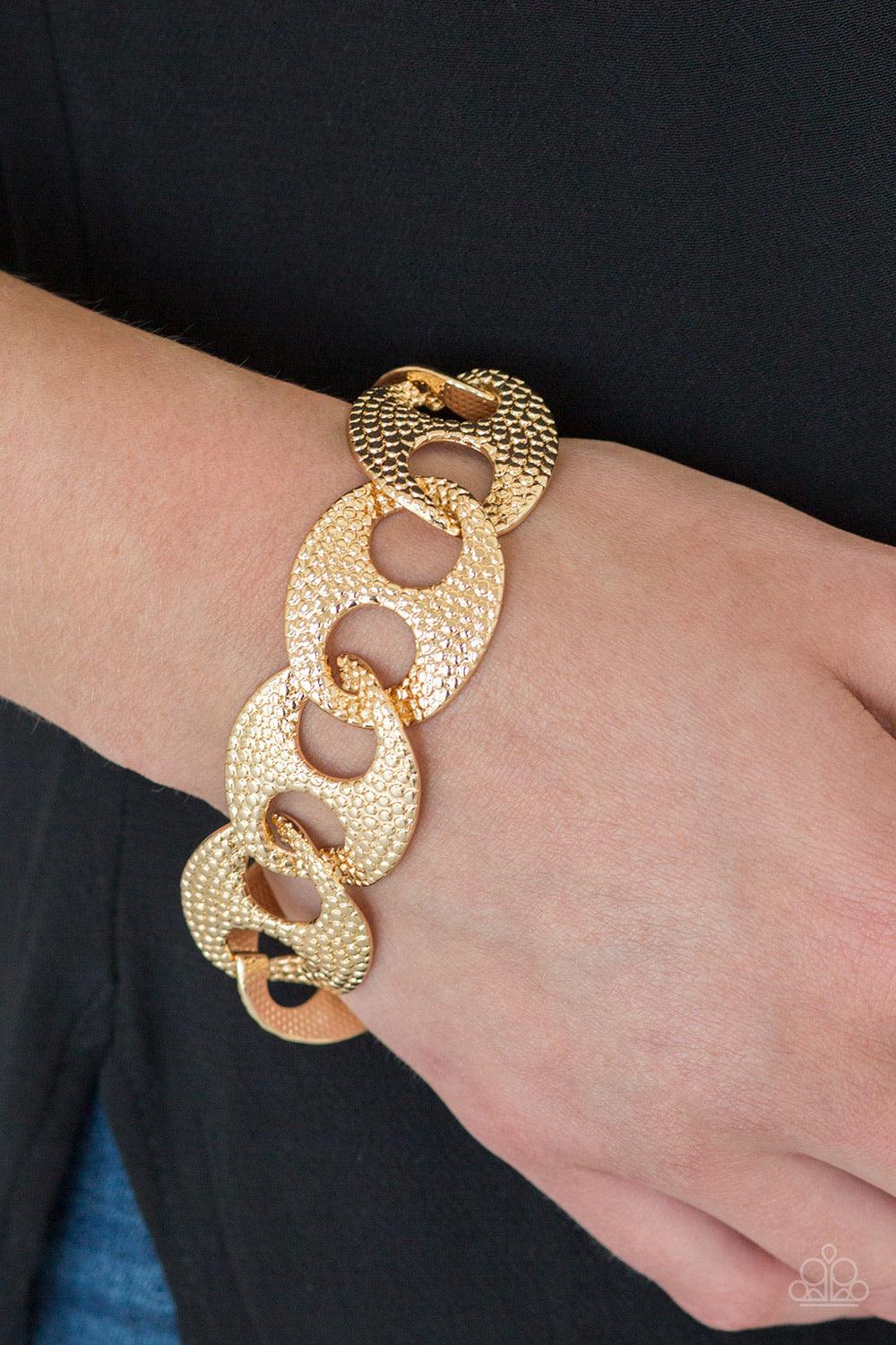 Paparazzi Accessories Casual Connossieur - Gold Embossed in shimmery circular patterns, asymmetrical gold frames link across the wrist for a casually industrial look. Features an adjustable clasp closure. Jewelry