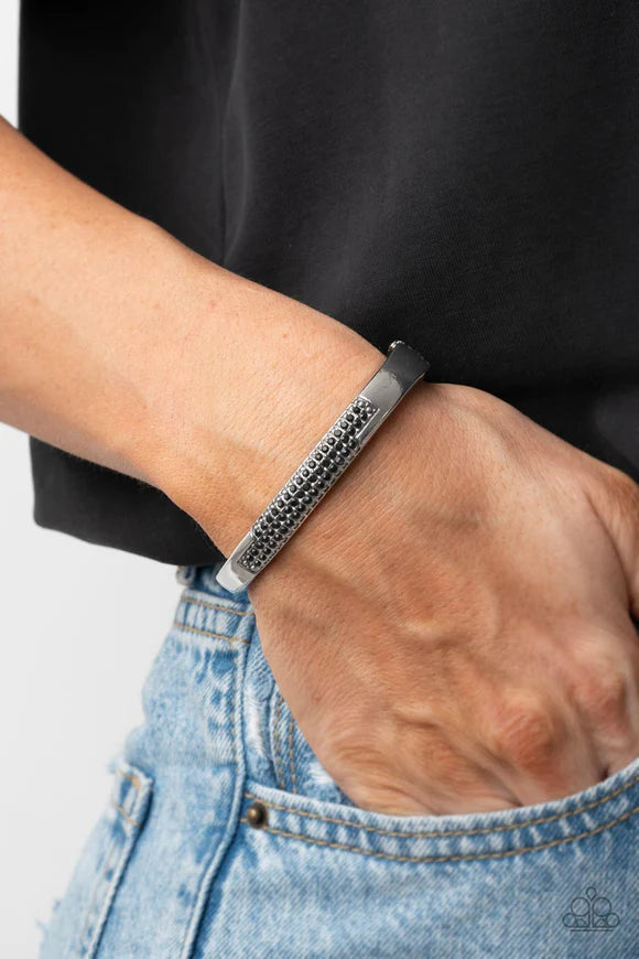 Paparazzi Accessories Chart-Topping Twinkle - Black The front of a silver frame is chiseled away, revealing two rows of glitzy black rhinestones across the center of a gritty bangle-like bracelet. Features a hinged closure. Sold as one individual bracelet