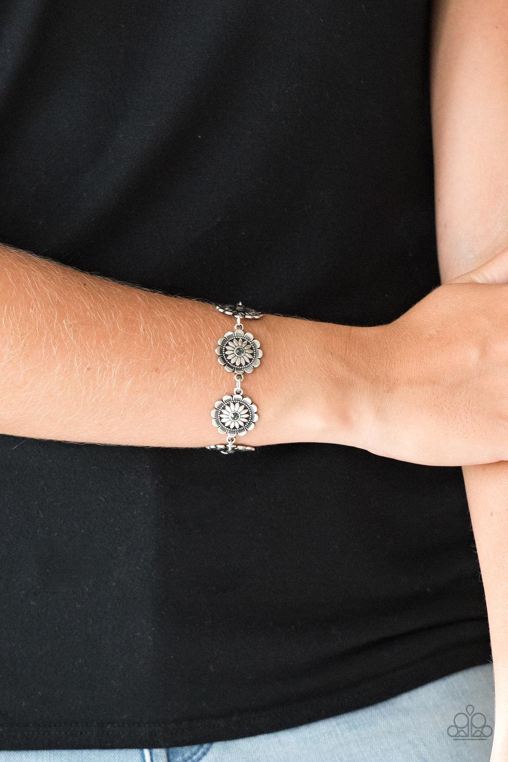 Paparazzi Accessories Funky Flower Child - Silver Dotted with smoky rhinestone centers, ornate silver floral frames link across the wrist for a seasonal look. Features an adjustable clasp closure. Sold as one individual bracelet. Jewelry