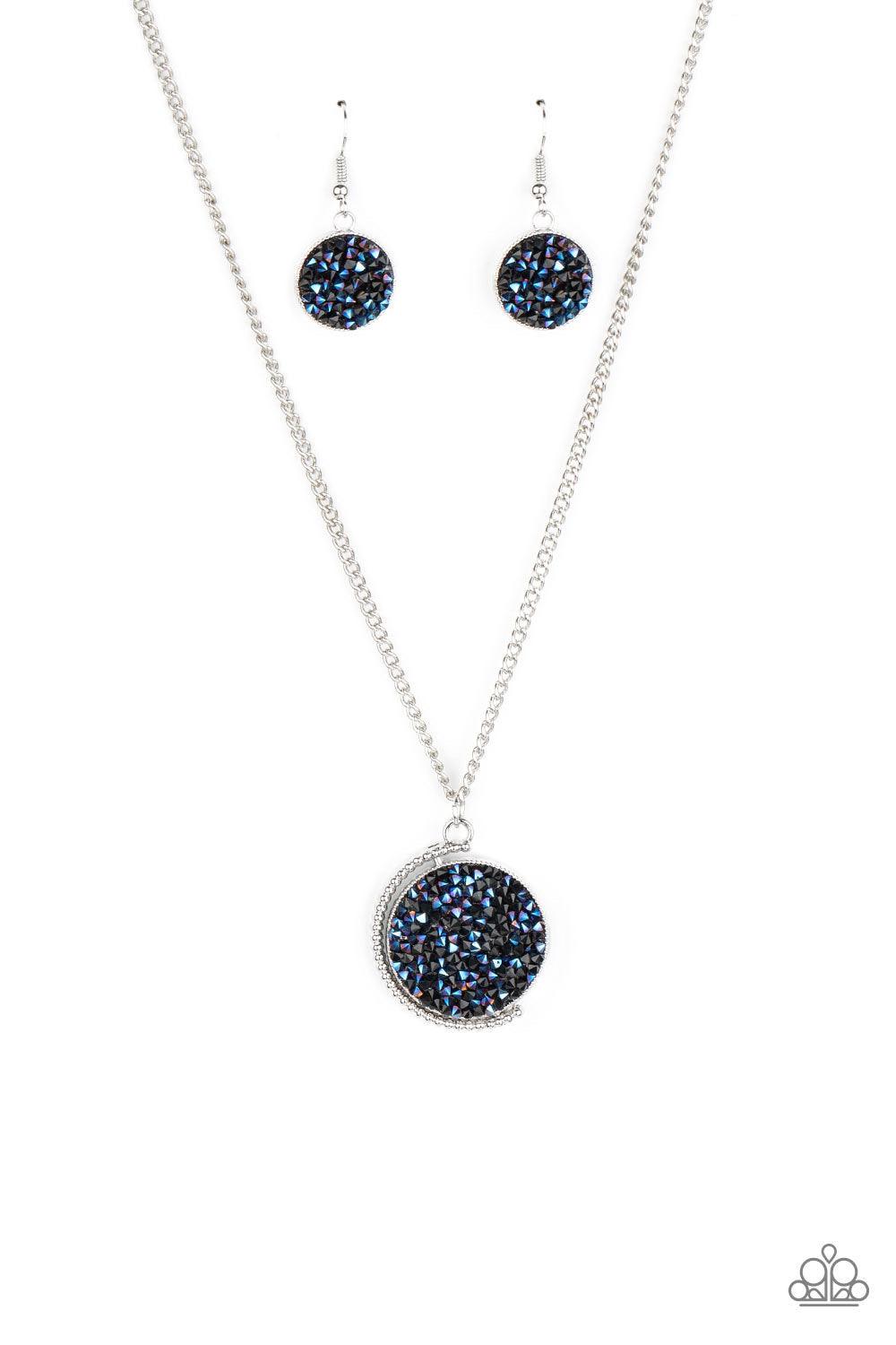 Paparazzi Accessories My Moon And Stars - Blue A smoldering collision of black and metallic blue rhinestones are encrusted across the front and back of a textured silver disc below the collar. Threaded along a dainty rod, the glittery pendant effortlessly