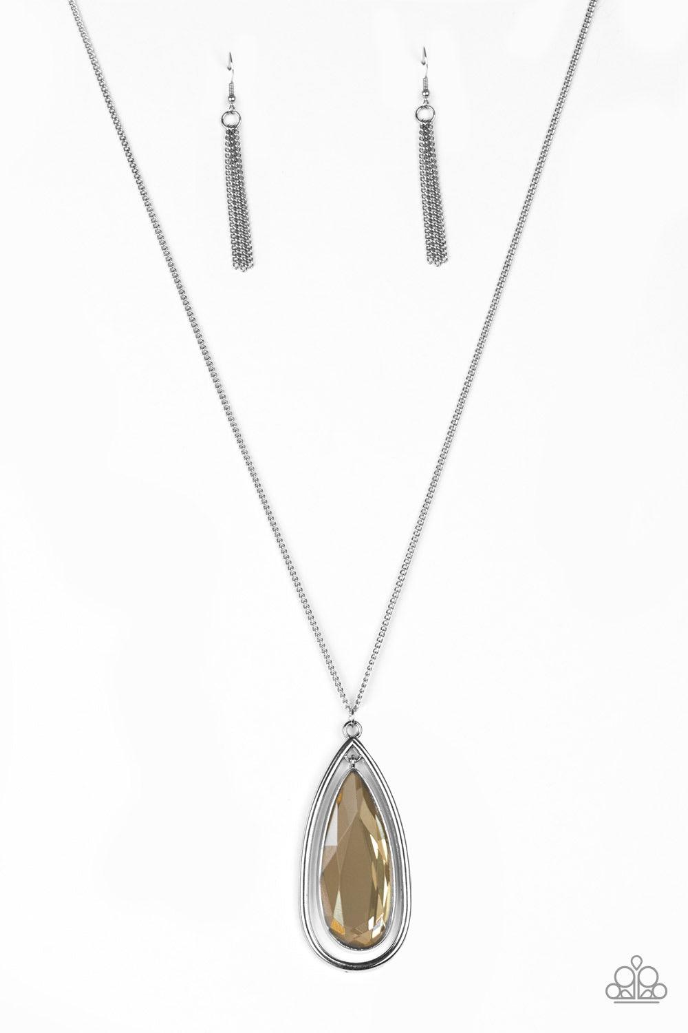 Paparazzi Accessories The Royal Coronation - Brown An oversized golden teardrop gem swings from the top of a glistening silver teardrop frame. The dramatic pendant swings from the bottom of an elegantly elongated silver chain for a regal finish. Features