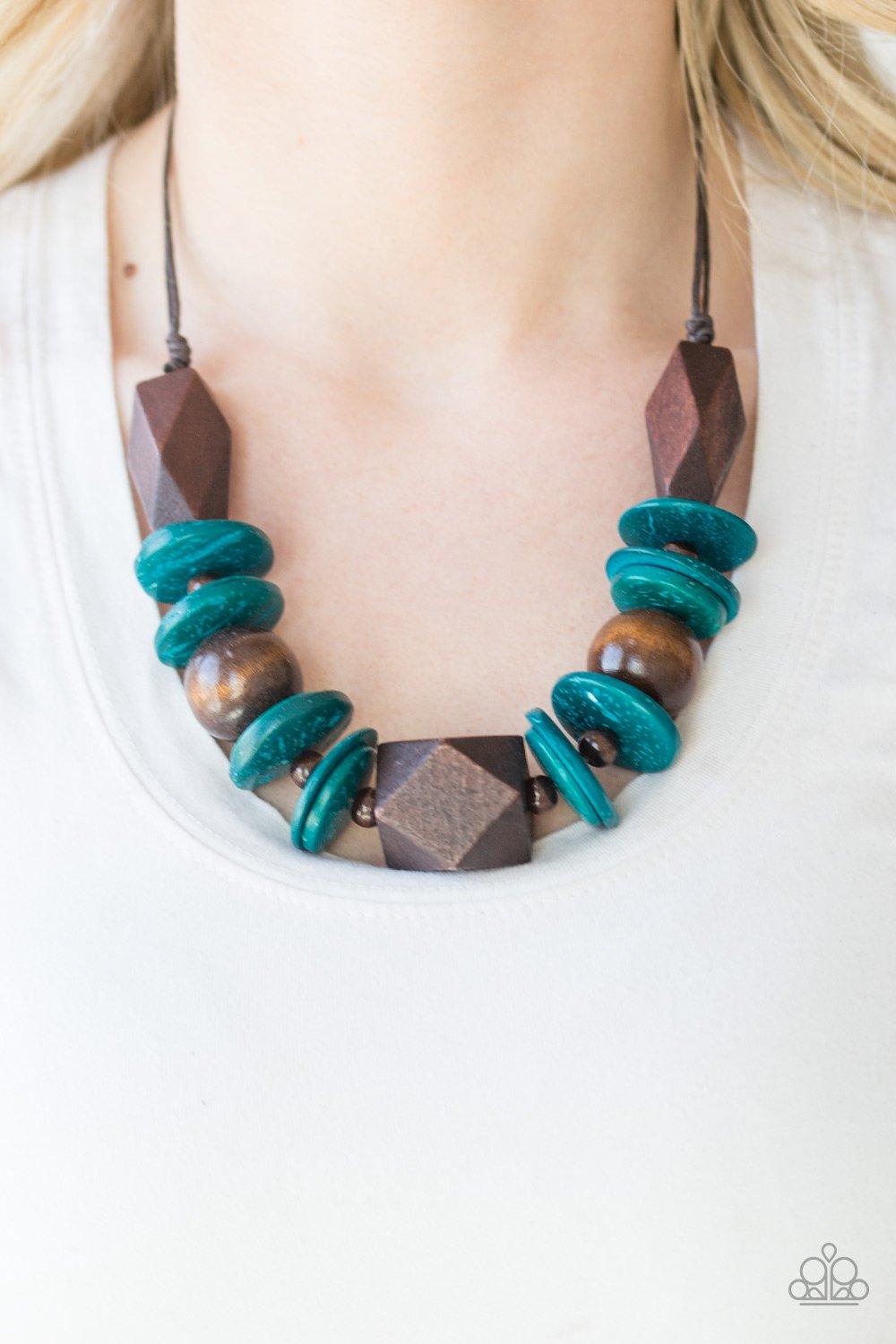 Paparazzi Accessories Pacific Paradise - Blue Featuring abstract geometric finishes, mismatched brown wooden beads and refreshing blue accents are threaded along shiny brown cording. A dramatic geometric bead adorns the center, creating a bold summery loo
