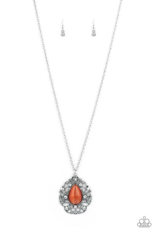 Paparazzi Accessories Bewitched Beam - Orange Glassy white rhinestones dot the front of a studded silver filigree frame that blooms out from a teardrop orange cat's eye stone, creating a bewitching pendant at the bottom of a lengthened silver chain. Featu