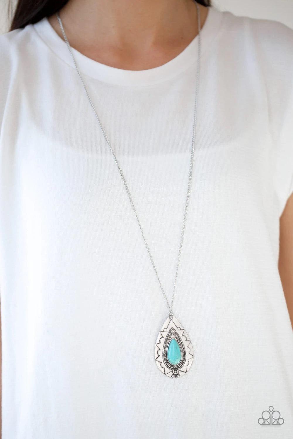 Paparazzi Accessories Sedona Solstice - Blue Chiseled into a tranquil teardrop, a refreshing turquoise stone is pressed into an ornate silver frame. The whimsical pendant swings from the bottom of a lengthened silver chain for a seasonal look. Features an