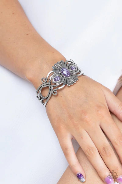 Paparazzi Accessories Rural Rumination - Purple Purple faux stone beads adorn the flared center of a frilly silver cuff layered with whirling smooth and textured silver filigree, creating a whimsical pop of color atop the wrist. Sold as one individual bra