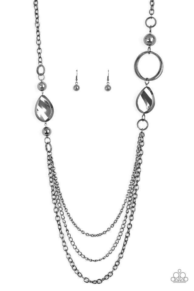 Paparazzi Accessories Rebels Have More Fun - Black A mismatched collection of oversized gunmetal beads, hoops, and textured gunmetal accents give way to layers of gunmetal chains down the chest for an edgy industrial look. Features an adjustable clasp clo