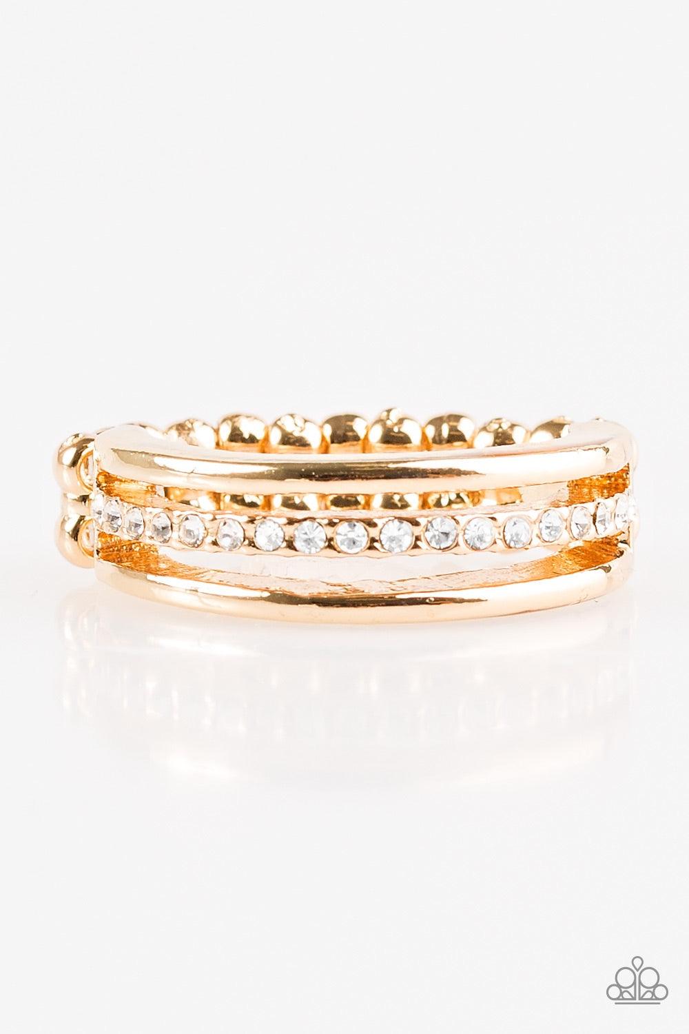Paparazzi Accessories Center Court - Gold Dainty gold bands layer across the finger. The centermost band is encrusted in white rhinestones for a glamorous finish. Features a dainty stretchy band for a flexible fit. Jewelry