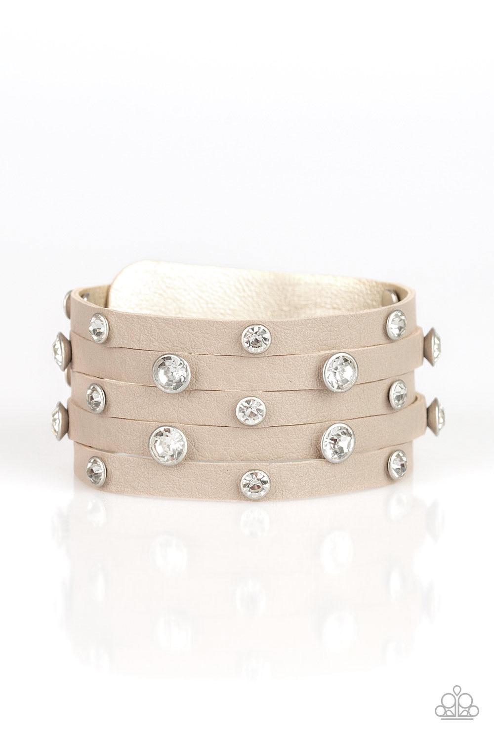 Paparazzi Accessories Rhinestone Reputation - Brown Dotted with glassy white rhinestones, a thick brown leather band has been spliced into five glittery strands around the wrist for a sassy look. Features an adjustable snap closure. Sold as one individual
