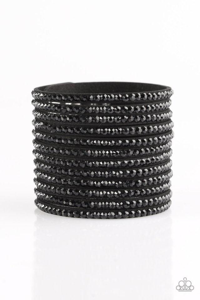 Paparazzi Accessories The Boss is Back - Black A thick black suede band is spliced into various strands. Glittery black rhinestones are sprinkled across the strands, creating blinding shimmer around the wrist for a knockout look. Features an adjustable sn