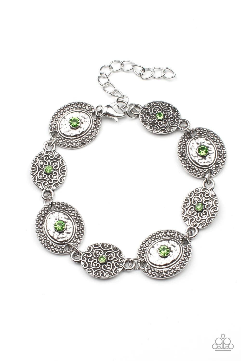 Paparazzi Accessories Secret Garden Glamour - Green Delicate Peridot rhinestones dot the centers of engraved antiqued silver discs. The dotted textures and heart shaped vines create a charming impression as they gracefully link around the wrist. Features