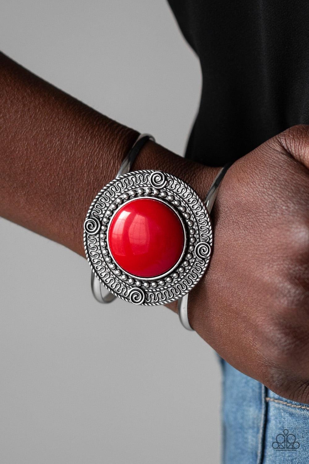 Paparazzi Accessories Tribal Pop - Red An oversized red bead is pressed into the center of a round silver frame radiating with swirly filigree detail. The bold frame sits atop an airy silver cuff for a vibrant pop of color. Jewelry