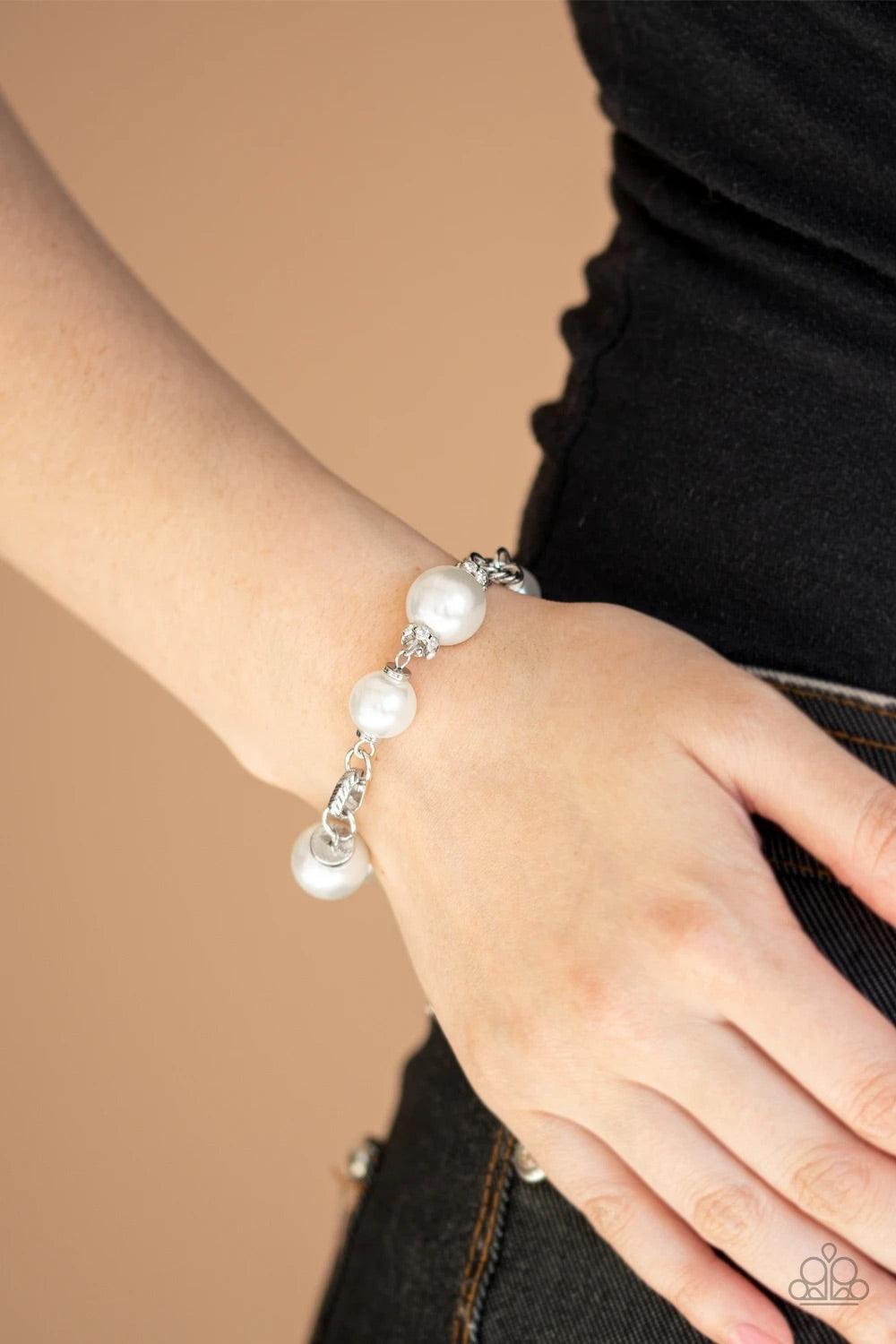 Paparazzi Accessories Boardroom Baller - White A classic collection of white pearls, white rhinestone encrusted rings, and ornate silver accents link across the wrist for a timeless look. Features an adjustable clasp closure.Sold as one individual bracele