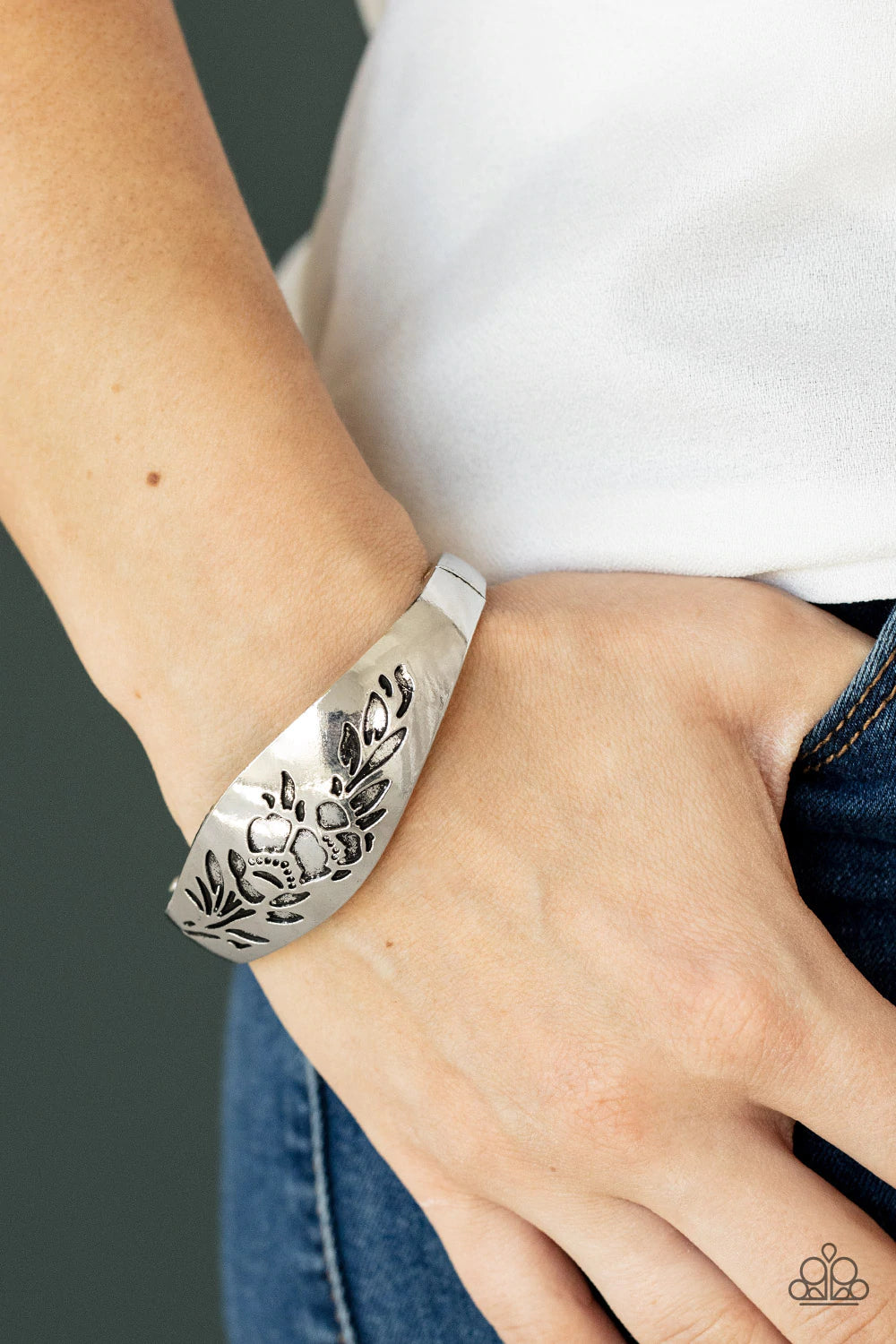 Paparazzi Accessories Fond of Florals - Silver The front of a thick antiqued silver bangle-like bracelet is stamped in a leafy floral pattern, creating a whimsy centerpiece around the wrist. Features a hinged closure. Sold as one individual bracelet. Jewe