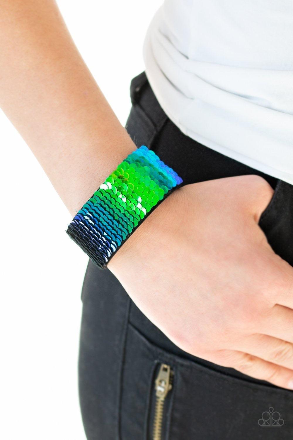 Paparazzi Accessories Mer-mazingly Mermaid - Blue Row after row of shimmery sequins are stitched across the front of a black suede band. Bracelet features reversible sequins that change from black to multicolor. Features an adjustable snap closure. Sold a