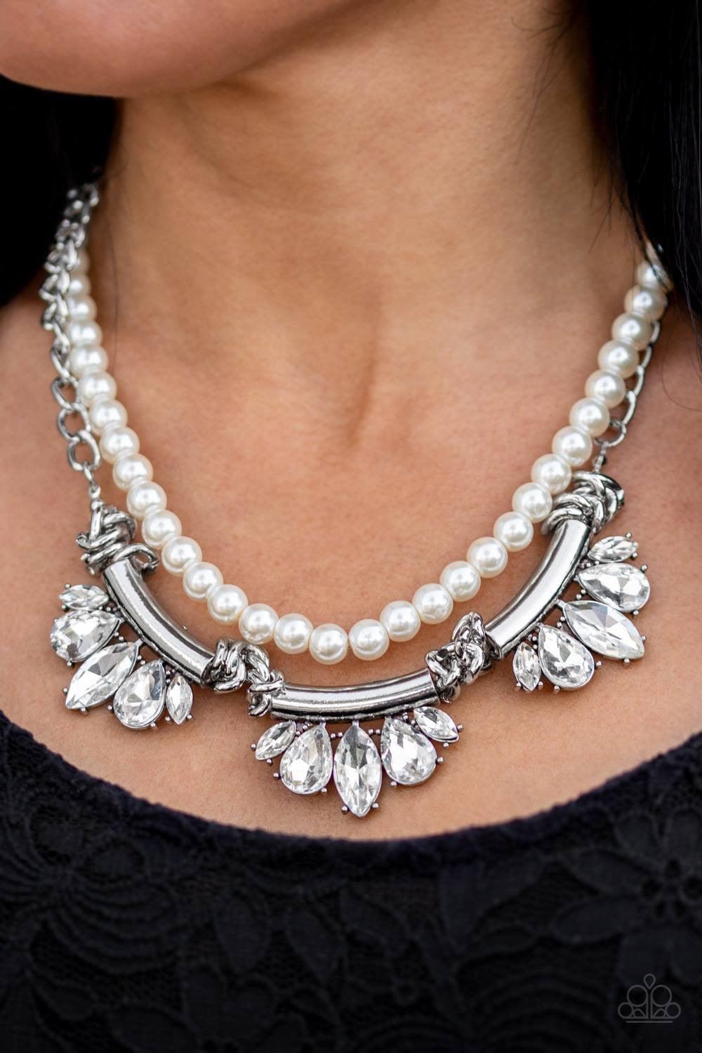 Paparazzi Accessories Bow Before The Queen - White A classic strand of white pearls and dramatic silvery chain drape below the collar. Infused with heavy metal accents, teardrop and marquise cut white rhinestone frames connect into a show-stopping fringe.