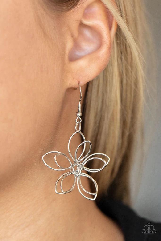Paparazzi Accessories Flower Garden Fashionista - Silver Shiny silver wire delicately twists into oversized blossoms. Varying in size, the airy floral frames delicately link into an asymmetrical display as the layered frames elegantly pop beneath the coll