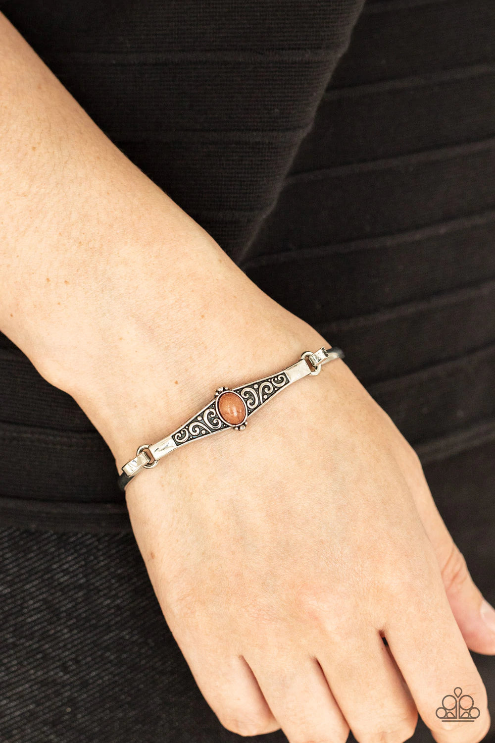 Paparazzi Accessories Stone Scrolls - Brown Dotted with an oval brown stone, an antiqued silver frame is embossed with a vine-like scroll that hooks to a dainty cuff-like bangle, creating a whimsical centerpiece. Sold as one individual bracelet. Bracelets