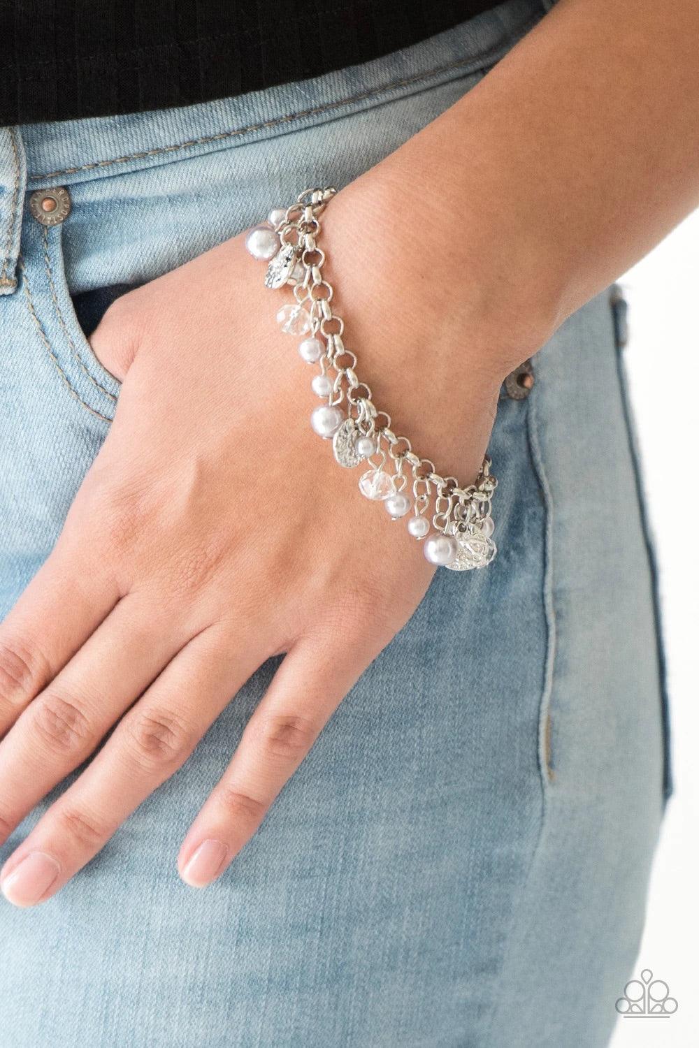 Paparazzi Accessories West Coast Wanderer - Silver Pearly silver beads, smoky crystal-like gems, and hammered silver discs swing from a bold silver chain, creating a refined fringe around the wrist. Features an adjustable clasp closure.Sold as one individ