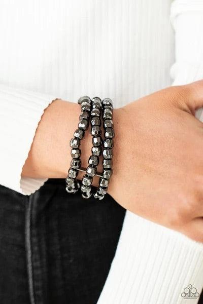 Paparazzi Accessories Magnetically Maven - Black Held together with dainty gunmetal fittings, rows of faceted gunmetal beads are threaded along stretchy bands around the wrist, coalescing into bold layers. Sold as one individual bracelet. Jewelry