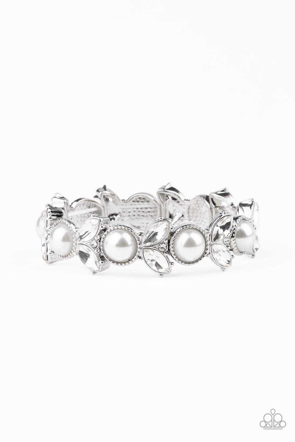 Paparazzi Accessories Opulent Oasis - White Encrusted in dazzling white rhinestones and an oversized white pearl, leafy silver frames are threaded along stretchy bands around the wrist for a timeless look. Sold as one individual bracelet. Jewelry