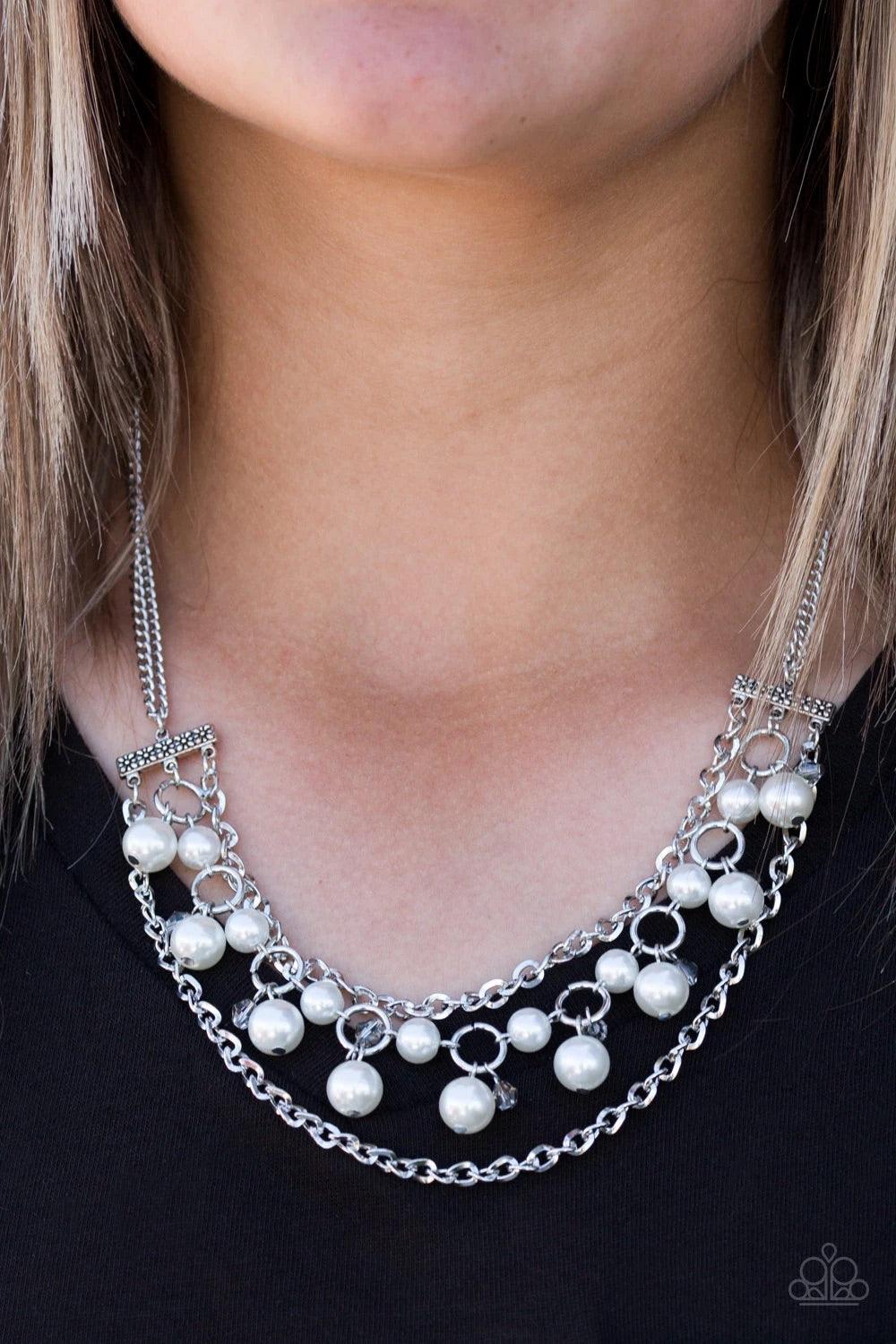 Paparazzi Accessories Rockefeller Romance ~White Attached to two floral fittings, rows of shimmery silver chains flank a pearly beaded strand below the collar. Dramatic white pearls and faceted crystal-like beads swing from the centermost strand for a ref