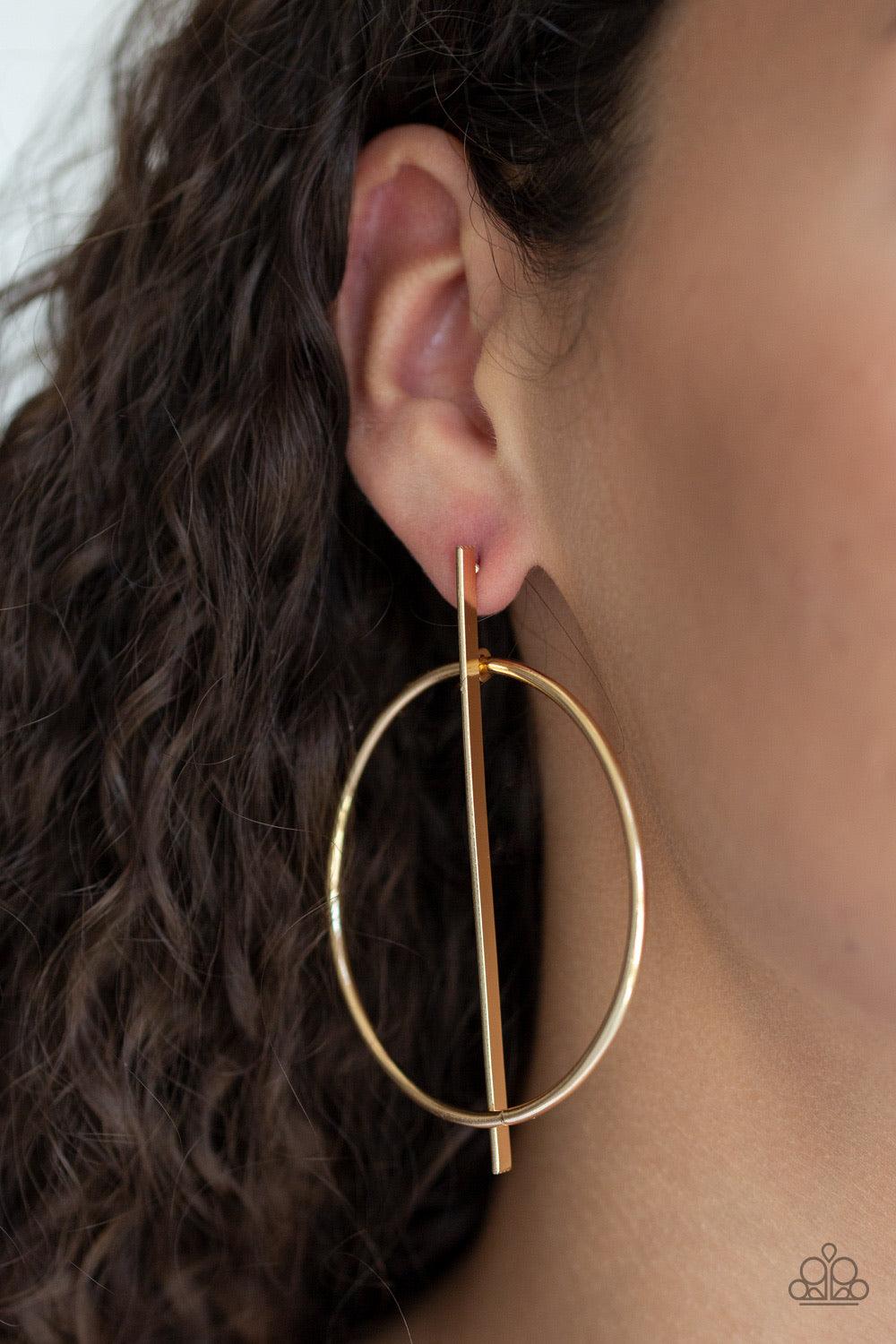 Paparazzi Accessories Vogue Visionary ~Gold A glistening gold hoop is threaded through a flat gold rod, creating an abstract frame. Earring attaches to a standard post fitting.