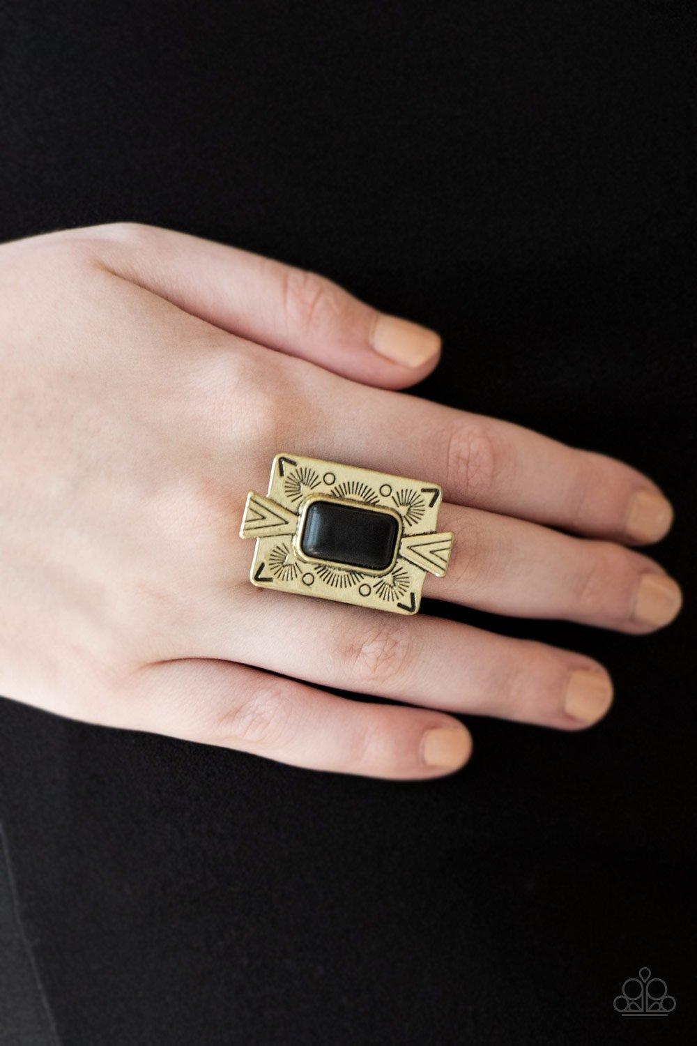 Paparazzi Accessories So Smithsonian - Brass Chiseled into a tranquil rectangle, an earthy black stone is pressed into a bold brass frame radiating with tribal inspired patterns for a seasonal look. Features a stretchy band for a flexible fit. Sold as one